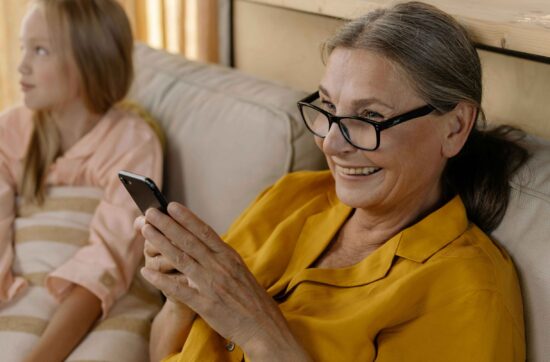 Un senior sur son portable avec un grand sourire