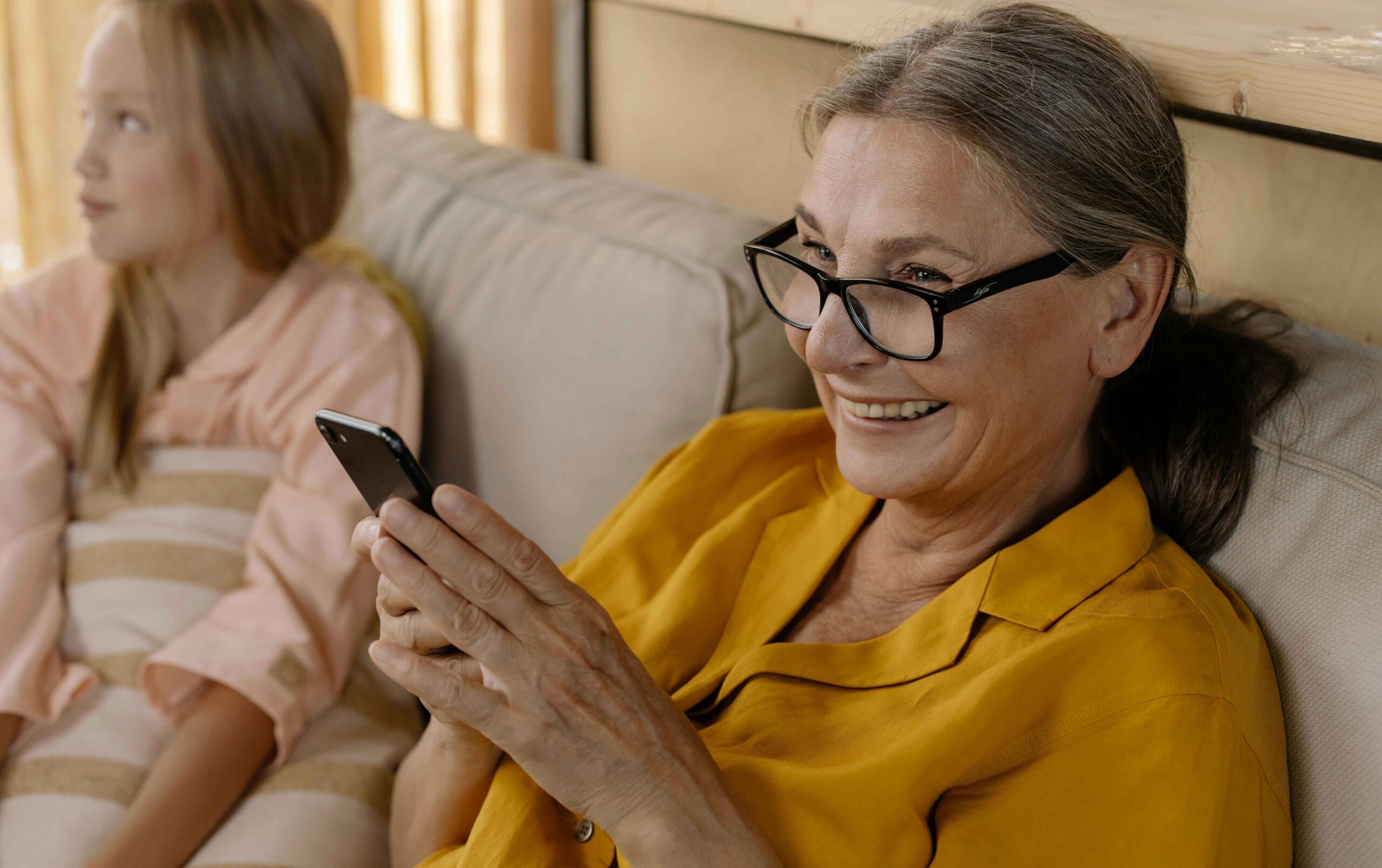 Un senior sur son portable avec un grand sourire